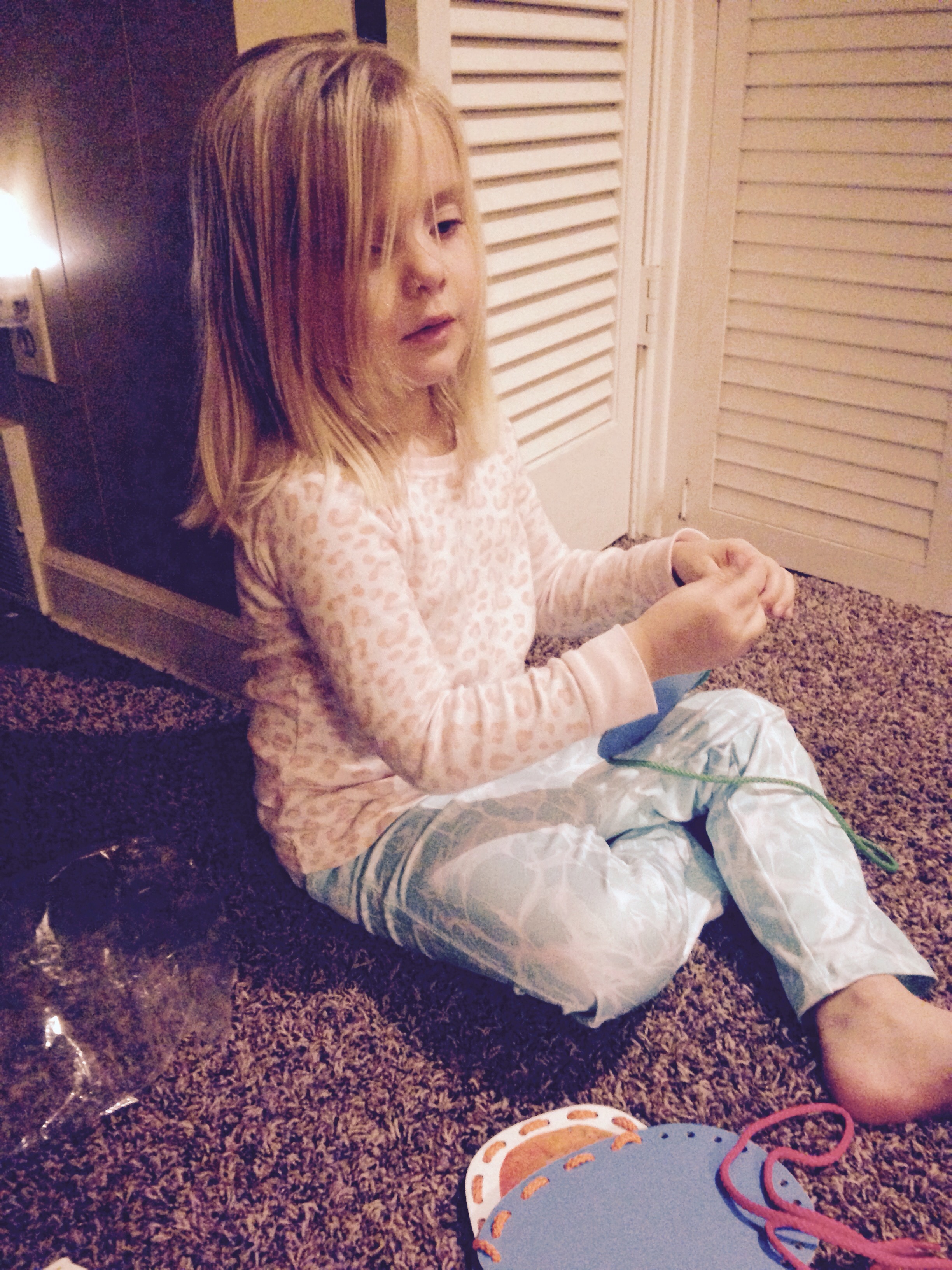 little girl playing with thread cards